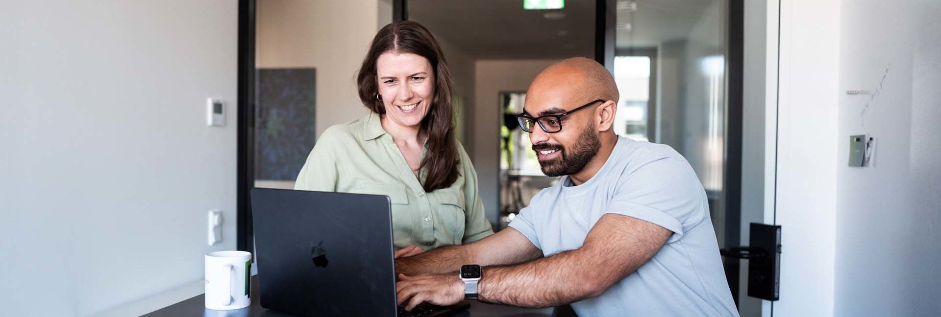 TYPO3 Relaunch Agentur: zwei Teammietglieder von mindshape schauen im Stehen auf Laptop