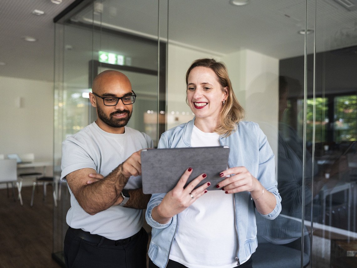 Zwei mindshapees schauen im Stehen auf ein Tablet